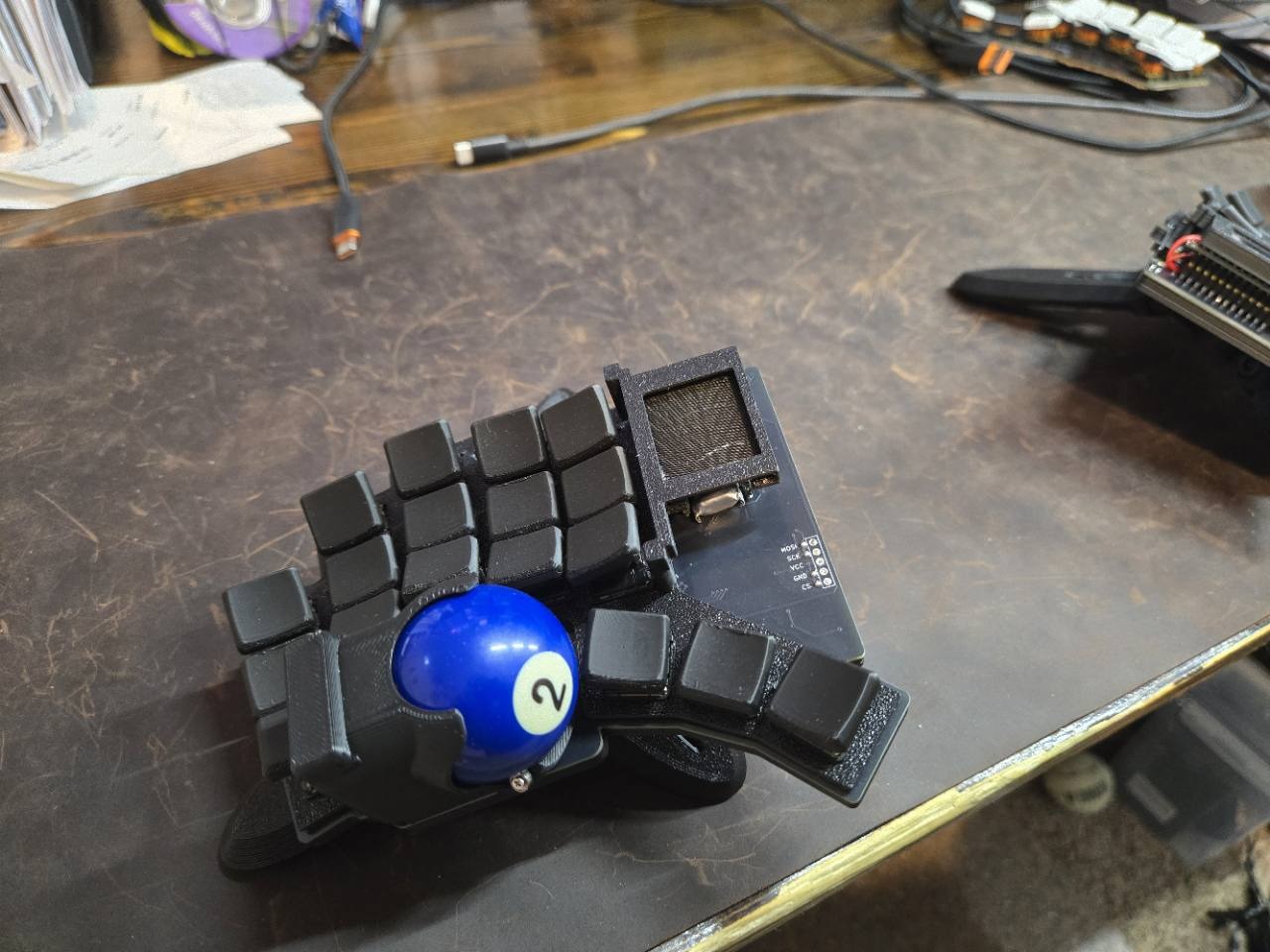 Tempest Dux prototype with a blue number-two trackball and printed supports.